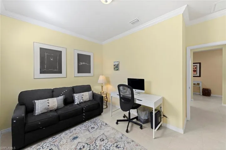 Office with crown molding and light tile patterned flooring