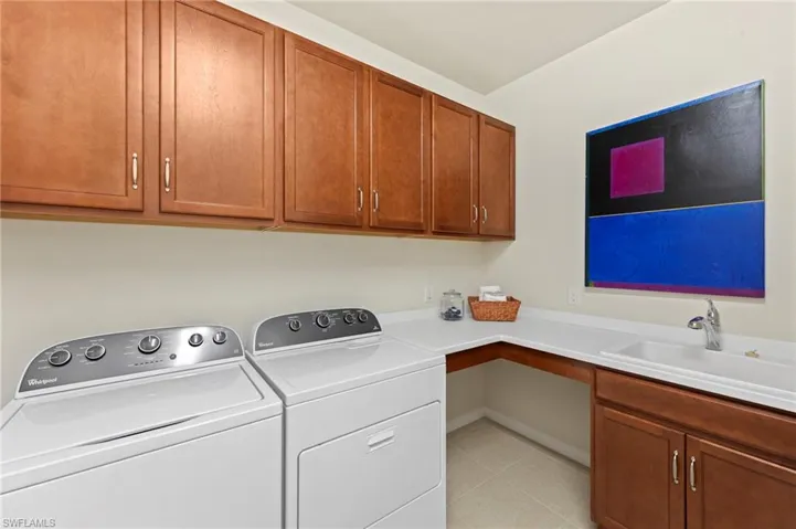 Laundry area featuring separate washer and dryer and cabinet space
