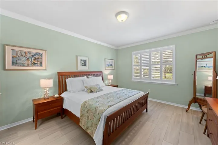 Bedroom with ornamental molding and light wood-style flooring