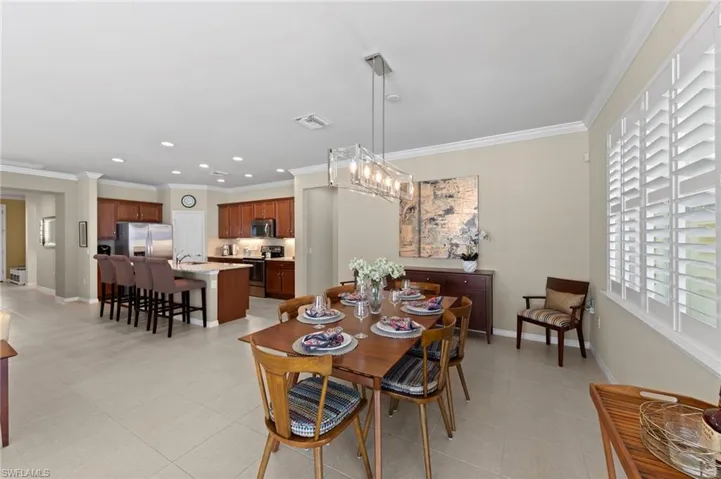 Dining space with ornamental molding, light tile patterned floors, a chandelier, and recessed lighting