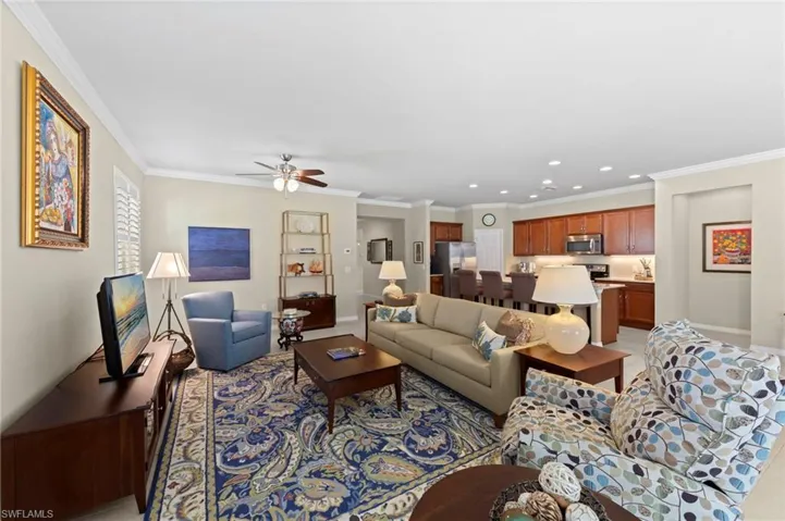 Living room with ornamental molding, ceiling fan, and recessed lighting