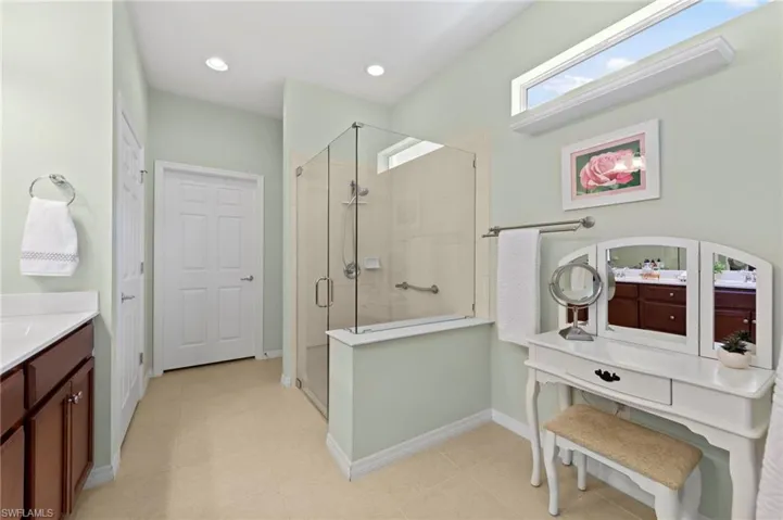 Bathroom with a shower stall, vanity, and recessed lighting