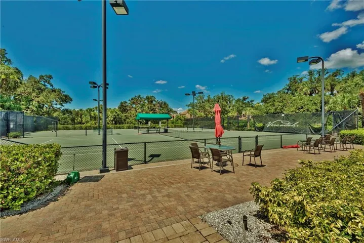 View of community featuring a tennis court and fence