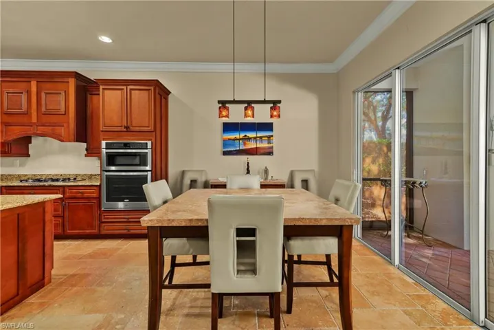 Dining room featuring ornamental molding, recessed lighting, and stone tile floors