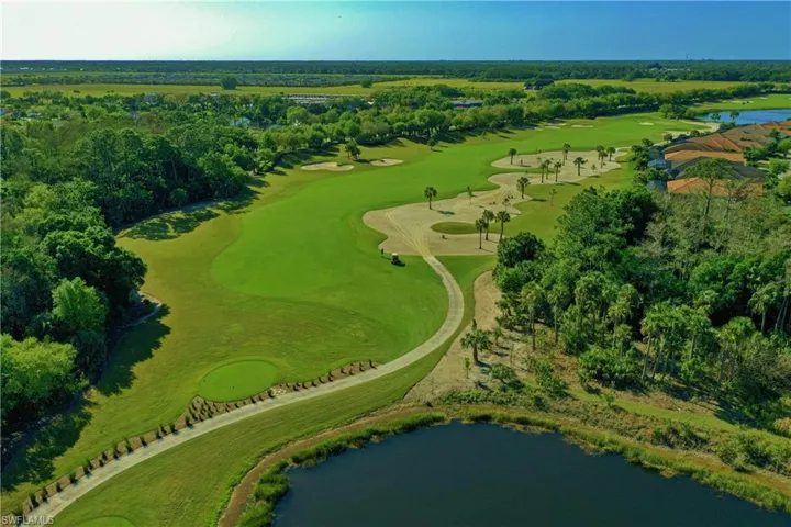 Birds eye view of property with view of golf course and a water view