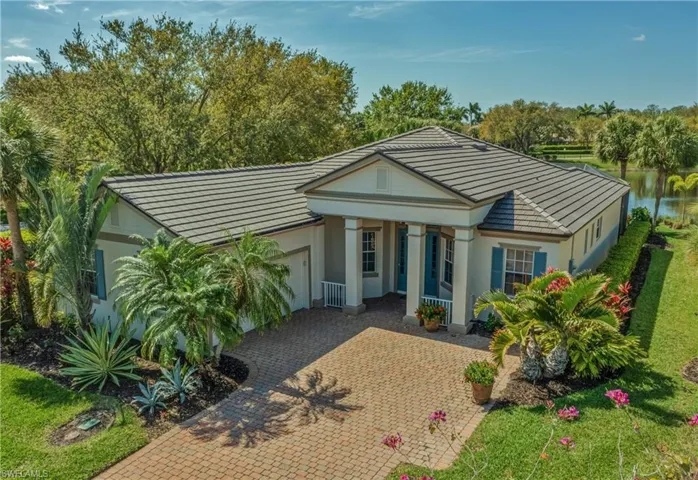 View of front of house featuring decorative driveway, an attached garage, a tile roof, and stucco siding