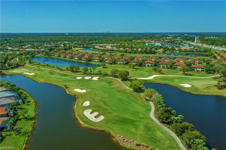 Birds eye view of property with view of golf course and a water view
