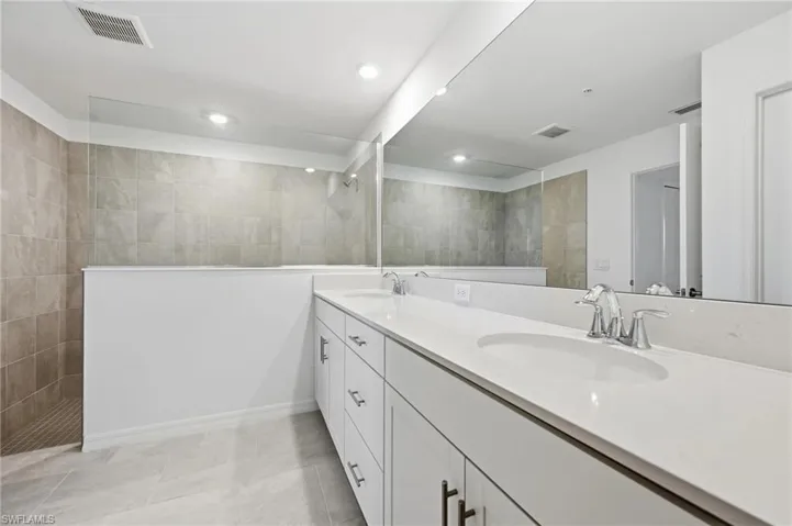 Bathroom with double vanity, a walk in shower, and recessed lighting