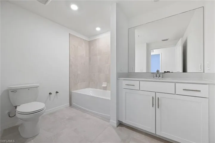 Bathroom with vanity, recessed lighting, and bathing tub / shower combination