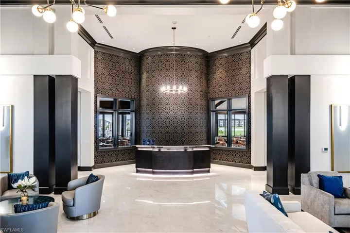 Reception area featuring a high ceiling, hanging lights, and ornamental molding