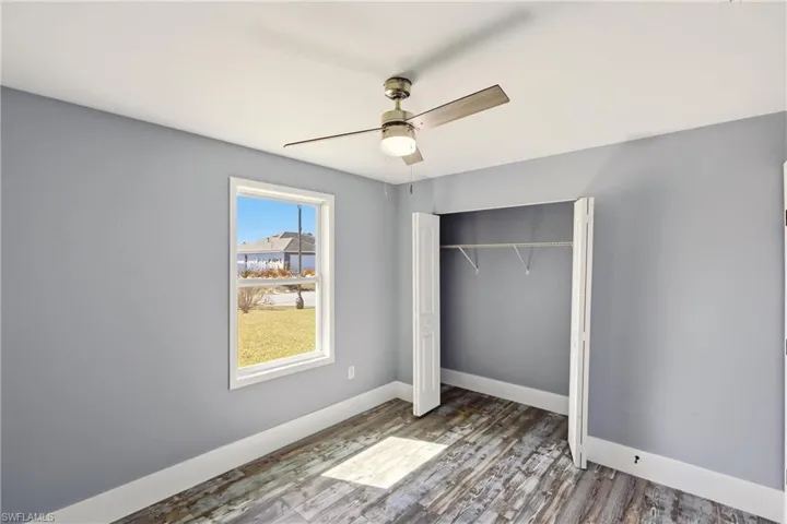 Unfurnished bedroom featuring a closet, wood finished floors, and ceiling fan