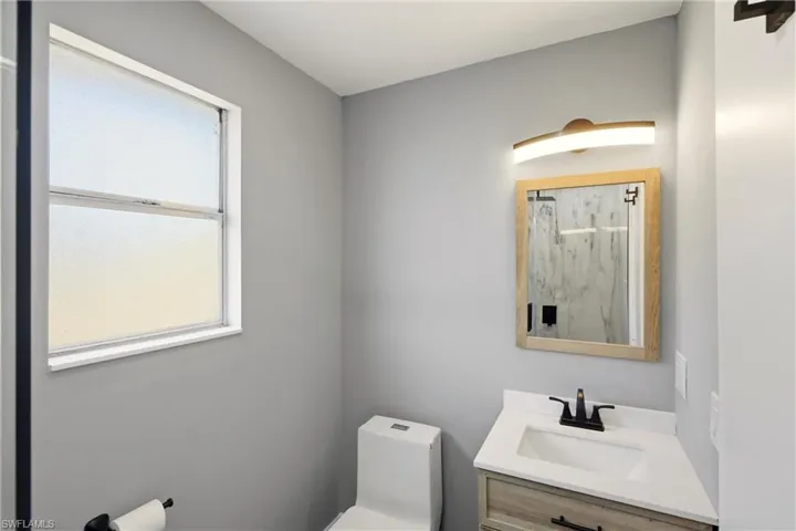 Bathroom with vanity and a marble finish shower