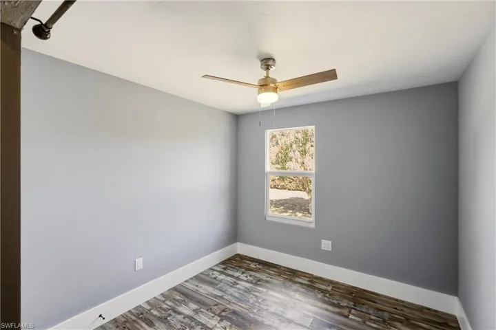 Unfurnished room featuring wood finished floors and a ceiling fan