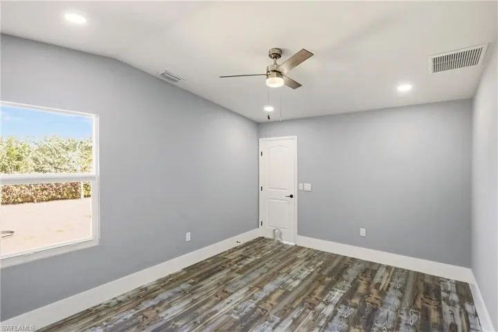 Unfurnished room with dark wood-style flooring, a ceiling fan, recessed lighting, and vaulted ceiling