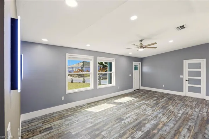 Unfurnished room featuring wood finished floors, a ceiling fan, and recessed lighting