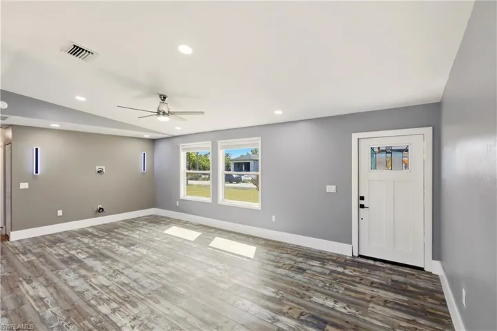 Entrance foyer with ceiling fan, vaulted ceiling, wood finished floors, and recessed lighting