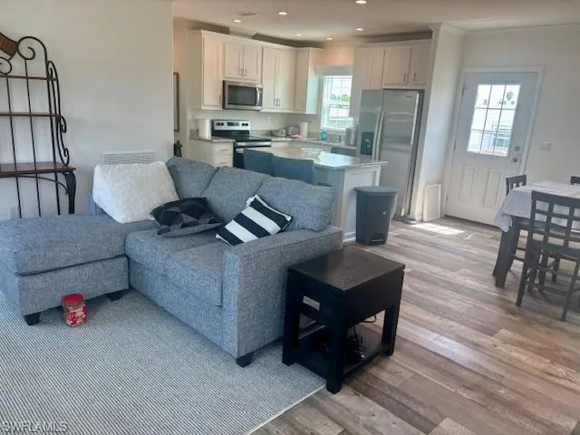 Living area featuring light wood-style flooring and recessed lighting