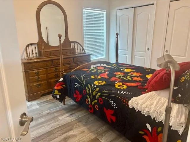 Bedroom featuring light wood-style floors and multiple closets