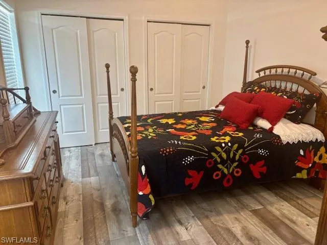 Bedroom with light wood-style floors and multiple closets