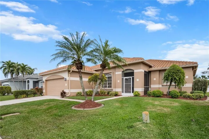 Mediterranean /Spanish-style home with a garage and a front yard