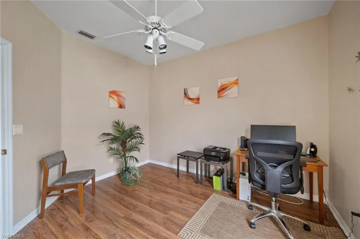 Home office with ceiling fan and light hardwood/wood-style floors