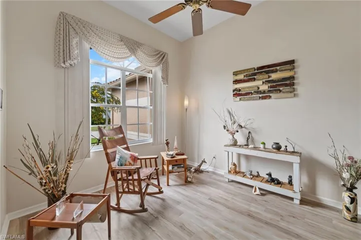 Living area with ceiling fan, plenty of natural light, and light hardwood / wood-style floors