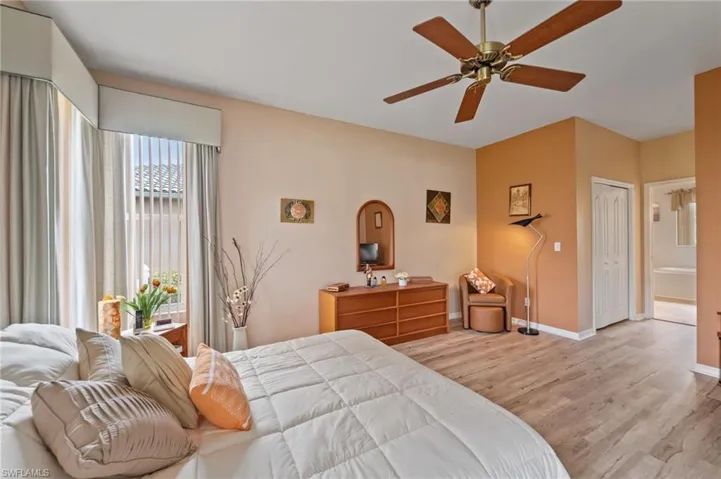 Bedroom with ceiling fan, a closet, ensuite bathroom, and light hardwood / wood-style flooring