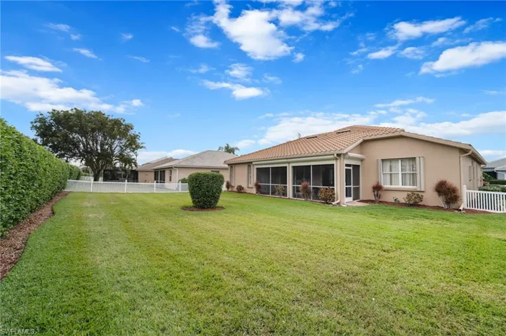 Back of house with a sunroom and a lawn