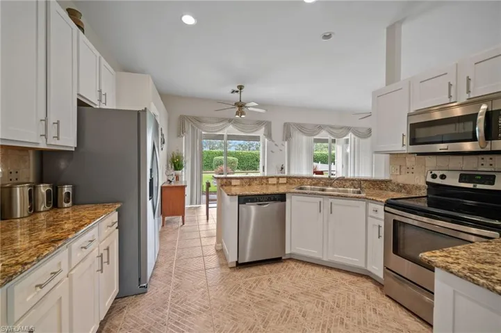 Kitchen with ceiling fan, appliances with stainless steel finishes, sink, and white cabinetry