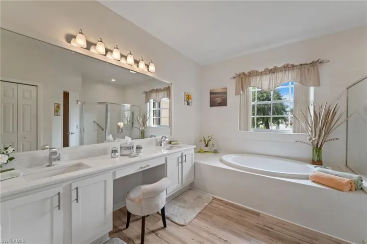 Bathroom featuring separate shower and tub, vanity, and hardwood / wood-style floors