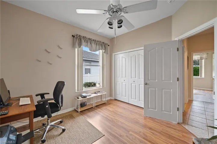 Home office with ceiling fan, light wood-type flooring, and a wealth of natural light