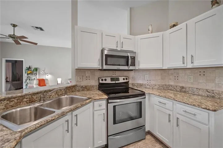 Kitchen with sink, white cabinets, and stainless steel appliances