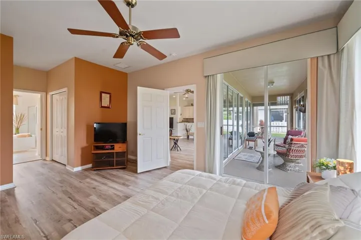 Bedroom featuring access to outside, ceiling fan, ensuite bathroom, and light hardwood / wood-style floors