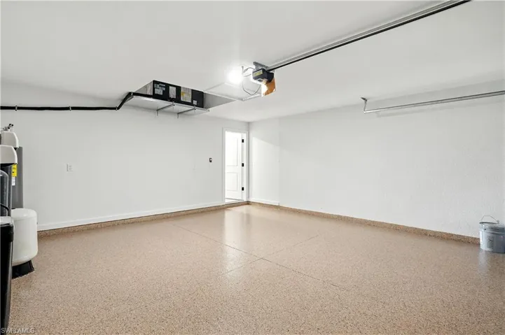Garage featuring baseboards and a garage door opener
