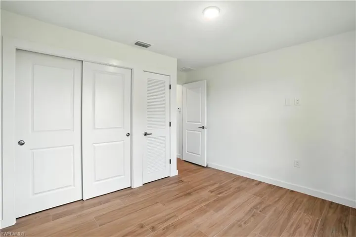Unfurnished bedroom with light wood-style floors and a closet