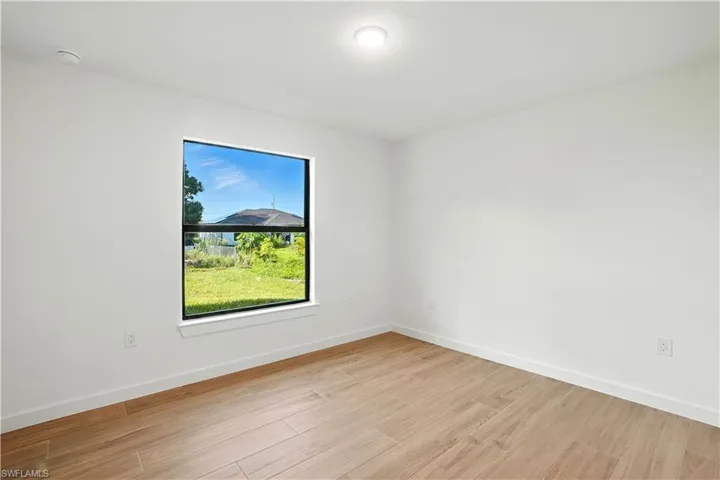 Empty room with baseboards and light wood-style flooring