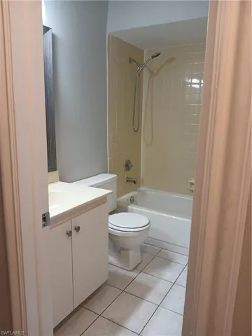 Bathroom featuring a white vanity cabinet, ceramic tile flooring, a tub-shower combination with tile surround, and a wall-mounted showerhead. Upstairs 2nd full bath