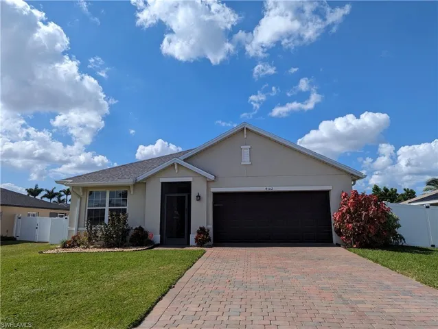 Ranch-style house with a front yard and a garage