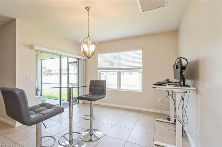 Sitting room with light tile flooring and a chandelier