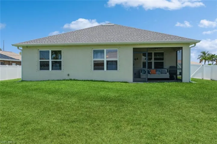 Back of house with a lawn