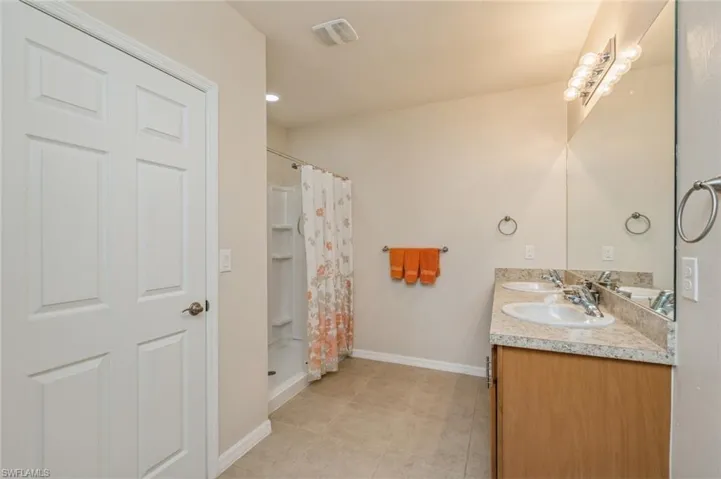 Bathroom featuring curtained shower, tile flooring, and vanity