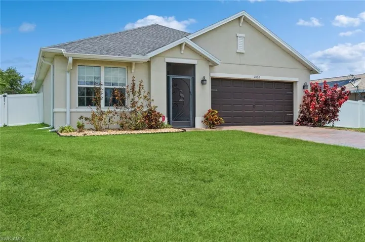 Single story home with a front yard and a garage