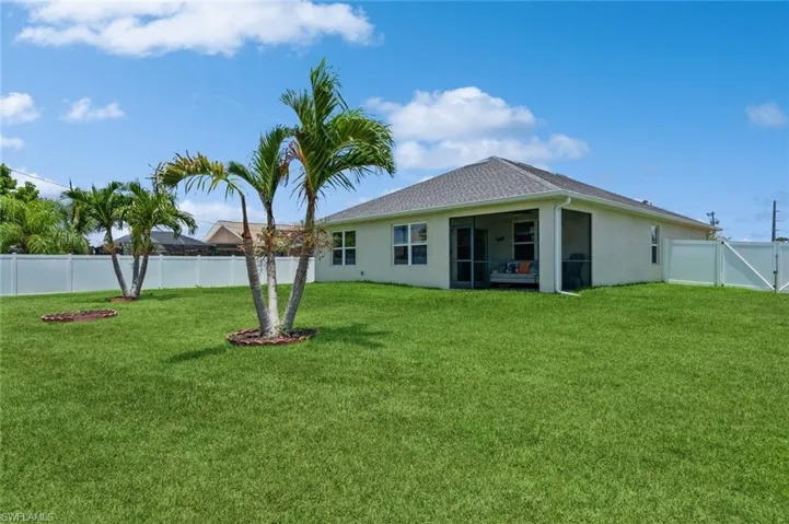 Back of house with a yard
