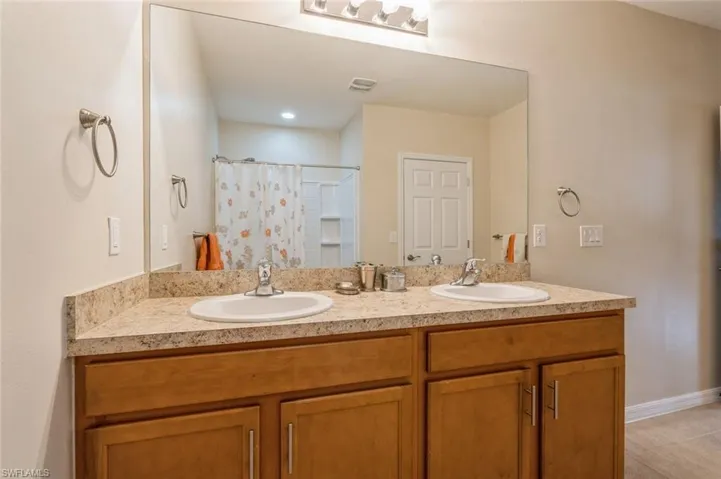 Bathroom with tile floors and dual vanity