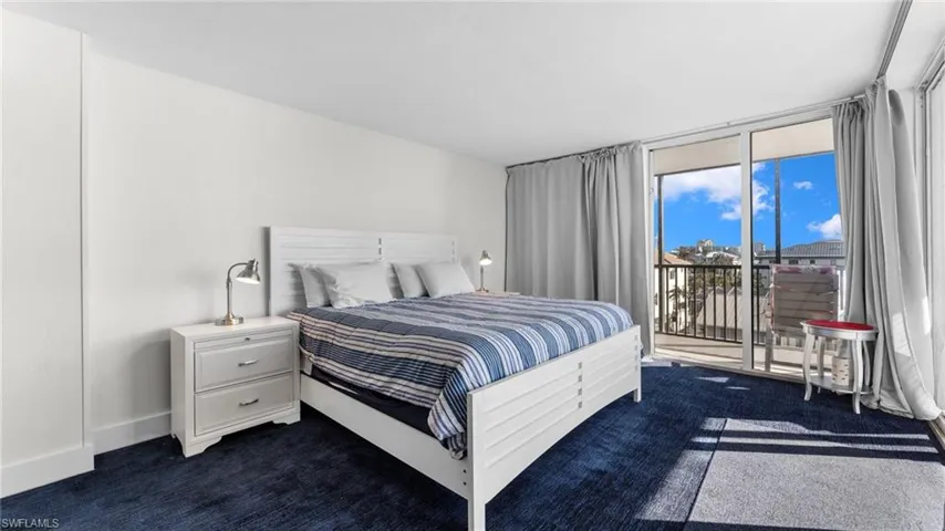 Bedroom with dark colored carpet and access to outside