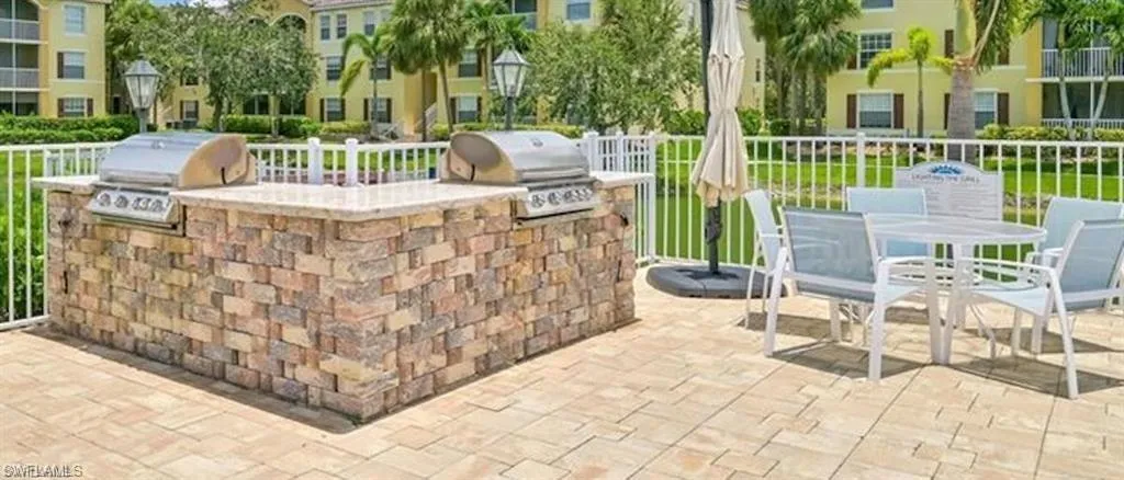View of patio featuring an outdoor kitchen and a grill