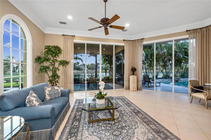 The family room is bright and cheery, with beautiful views to the lake, garden, and pool.