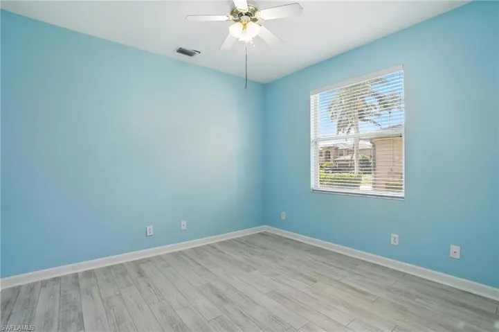 Spare room featuring wood finished floors and ceiling fan - Virtually Edited Image