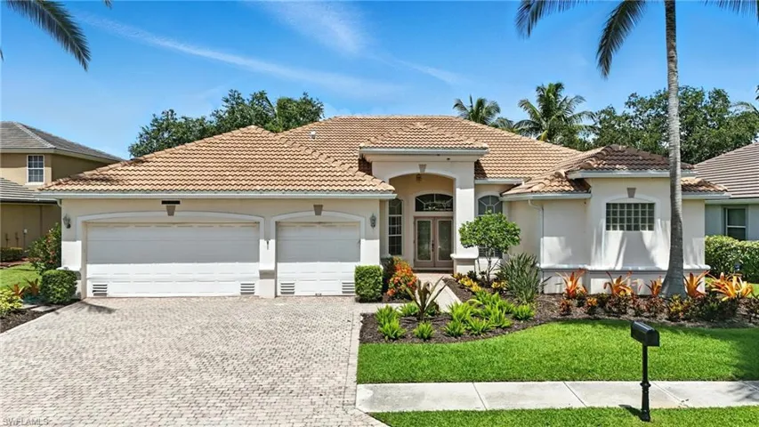 Mediterranean / spanish home with french doors, a garage, stucco siding, decorative driveway, and a tiled roof - Virtually Edited Image