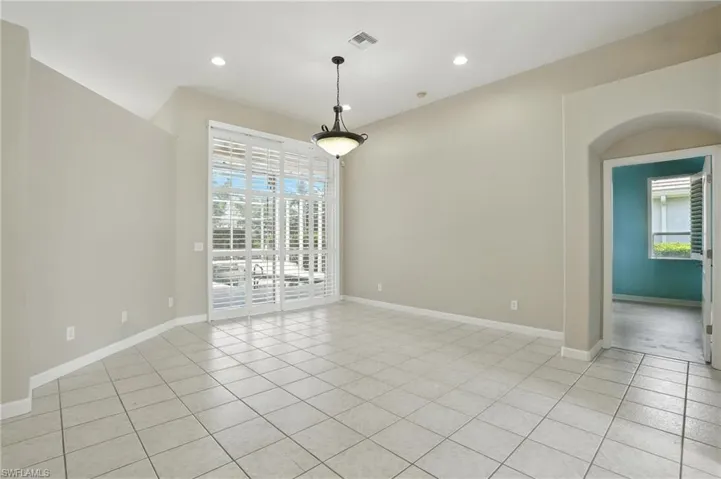 Family room featuring healthy amount of natural light, light tile patterned flooring, recessed lighting, and arched walkways - Virtually Edited Image